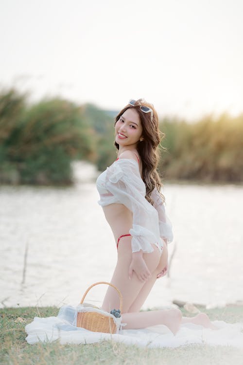 A woman in white underwear posing near the water