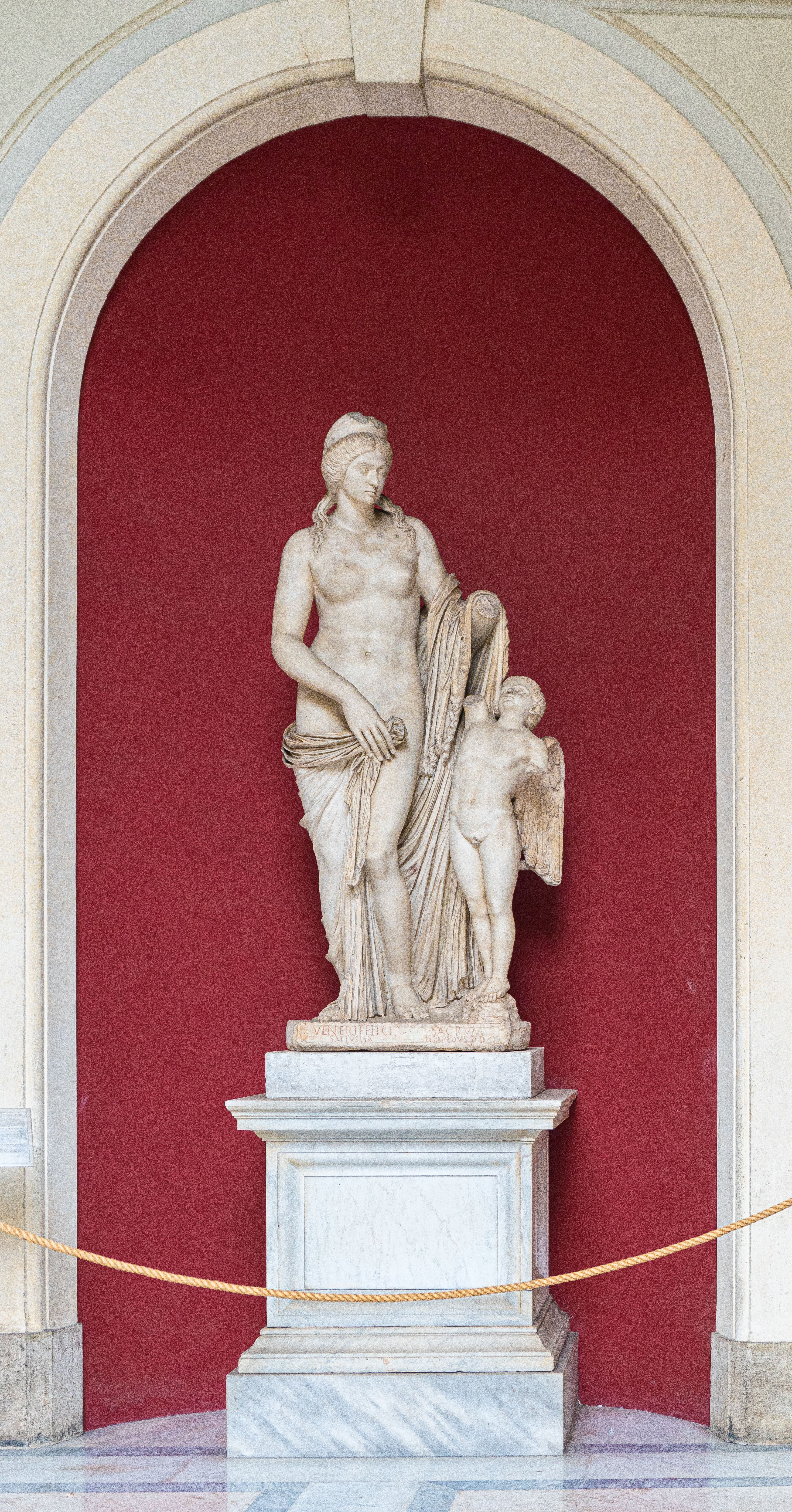 Marble sculpture of Venus Felix and Cupid in Vatican Museums' classic arch display.