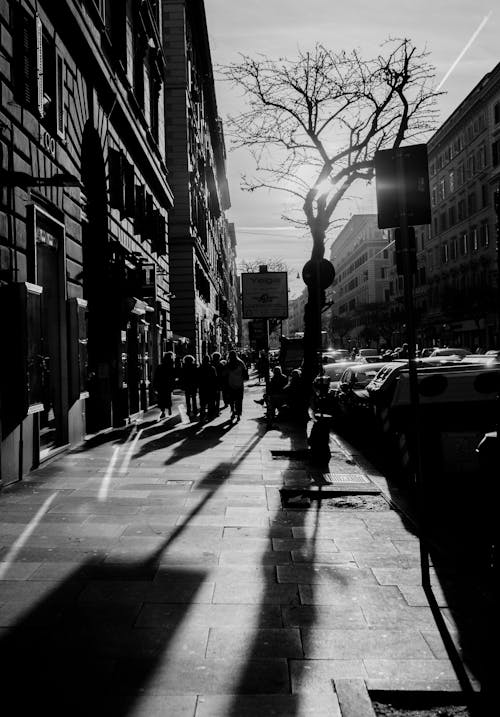 A black and white photo of a street with people walking