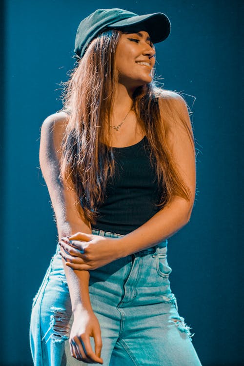 A woman in a cap and jeans standing on stage