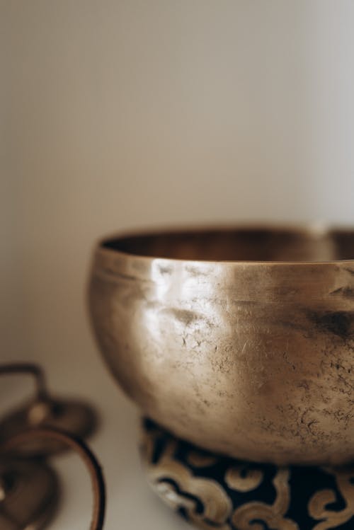 A singing bowl on a table with a candle