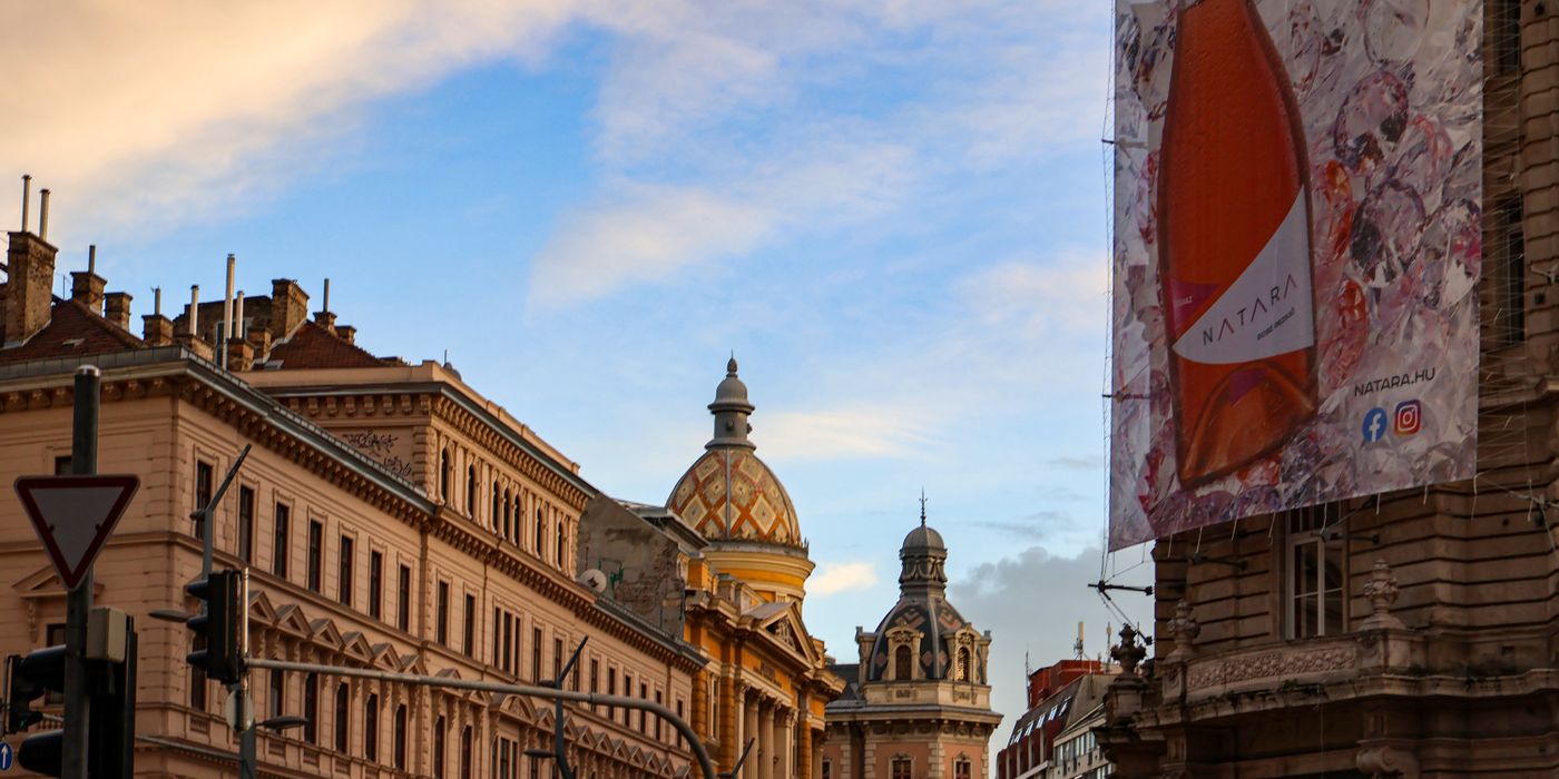 Stunning view of Budapest's historic buildings and architectural domes under a colorful sky.