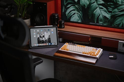 A desk with a keyboard and a tablet