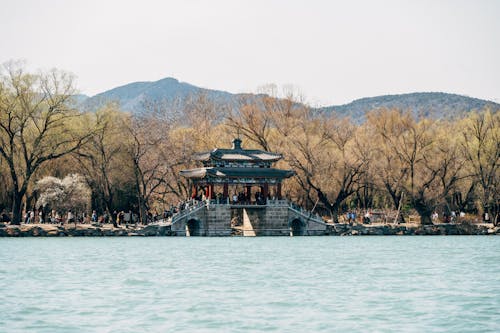 A pagoda on the water in front of mountains