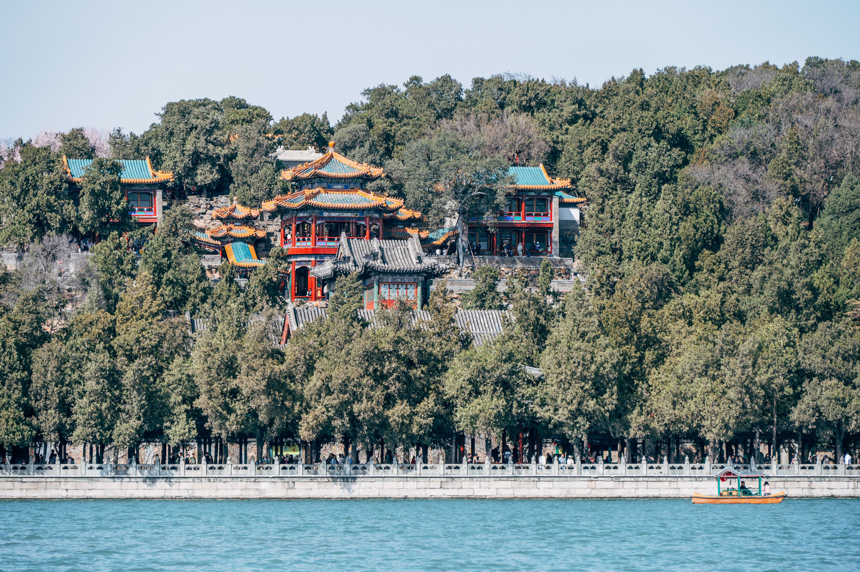 A picturesque view of the Summer Palace in Beijing surrounded by lush greenery and tranquil waters.