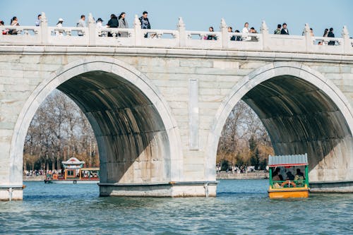 People are riding on a boat on a bridge