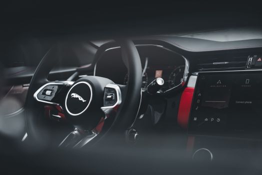 Sleek Jaguar SUV interior showcasing the modern steering wheel and dashboard features.