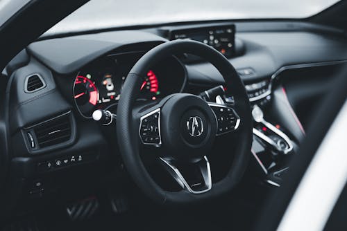 The interior of a car with a steering wheel and dashboard