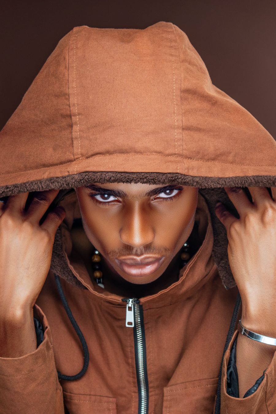 Editorial portrait of a man in a hooded jacket