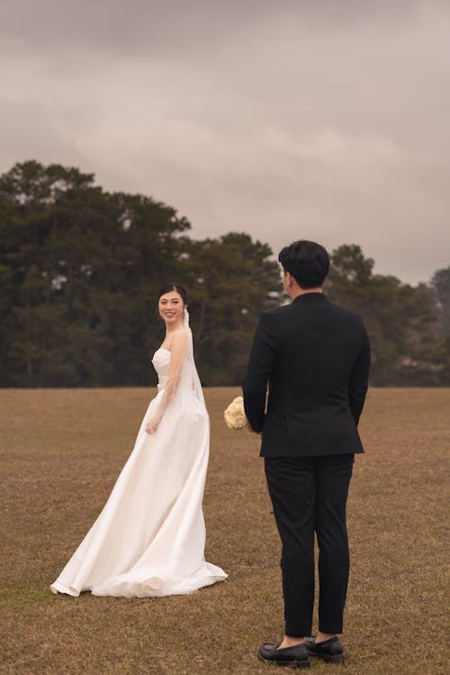 A bride and groom standing in a field