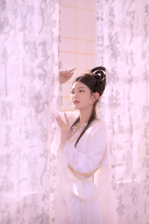 Free Serene image of a woman in traditional attire framed by curtains with calligraphy. Stock Photo