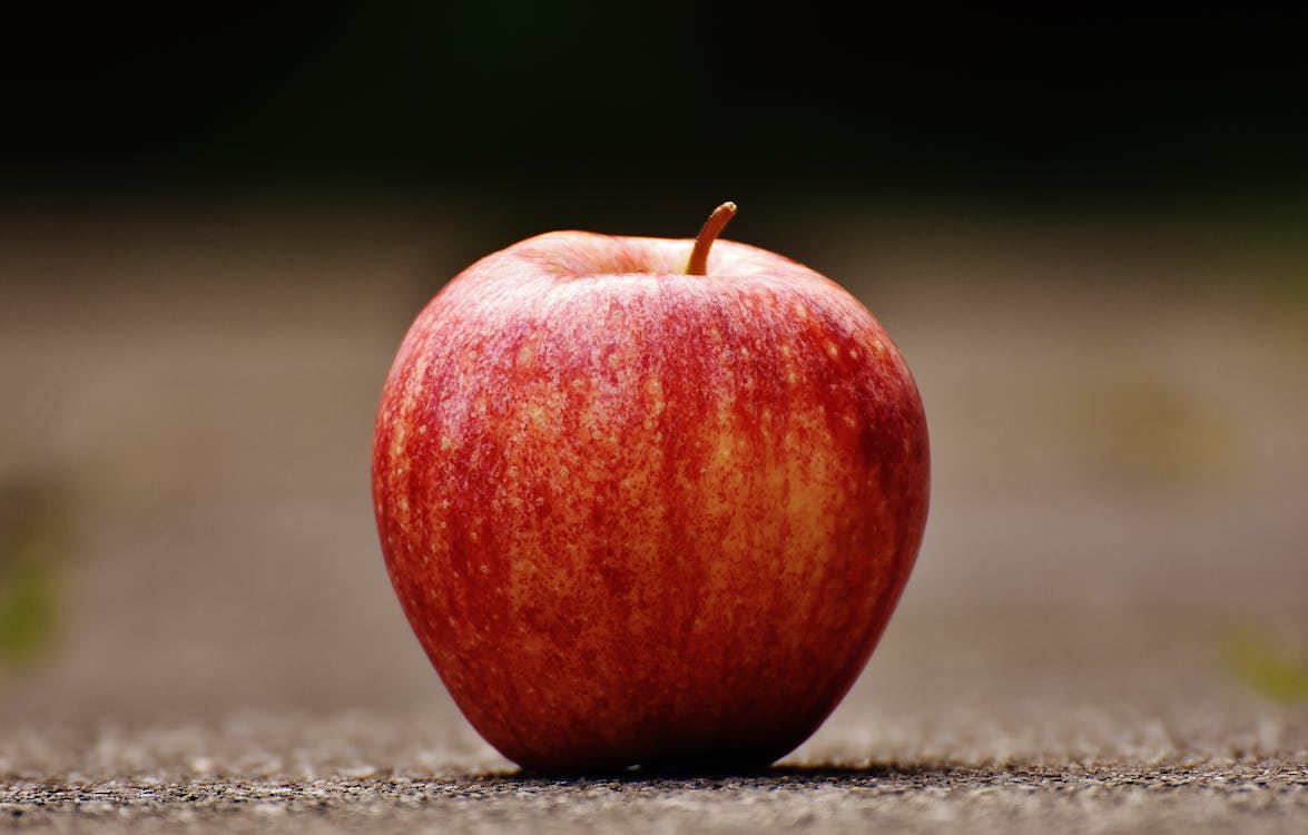 Free Shallow Focus Photography of Red Apple on Gray Pavement Stock Photo