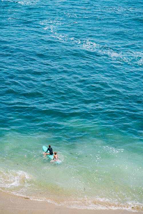 Foto profissional grátis de beira-mar, casal, fato de mergulho