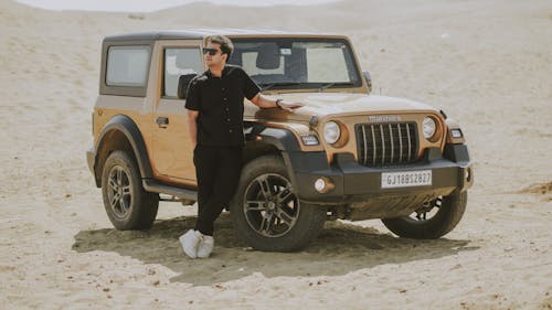 A woman standing next to a jeep in the desert