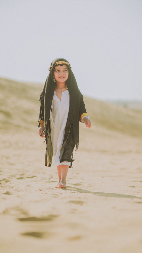 Little Girl with Headscarf Walking on Beach