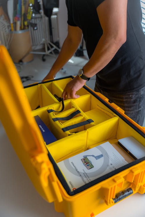 A man is opening a yellow case with a yellow book inside