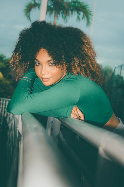 A woman with curly hair leaning over a railing