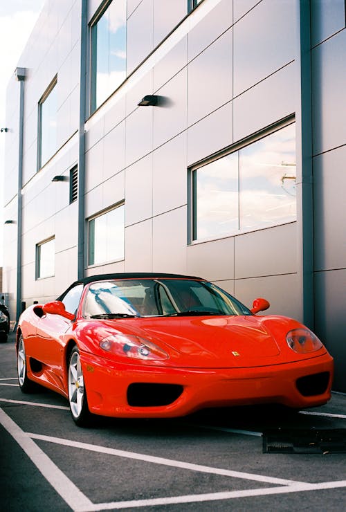 A red ferrari parked in front of a building