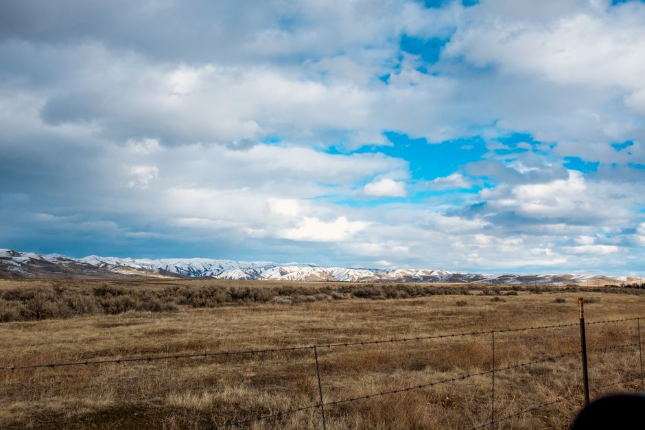 Peaceful landscape with snowy hills and cloud-filled sky near Boise, ID.