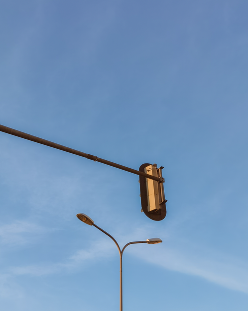 Free A street scene with a traffic light and clear blue sky, conveying minimalism and tranquility. Stock Photo