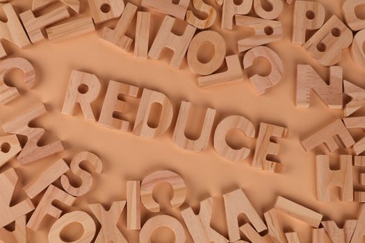 Top-view image of scattered wooden alphabet blocks with 'Reduce' prominently displayed.