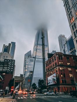 纽约市现代摩天大楼的朦胧景色与下方川流的交通，共同营造出一种忧郁的城市场景