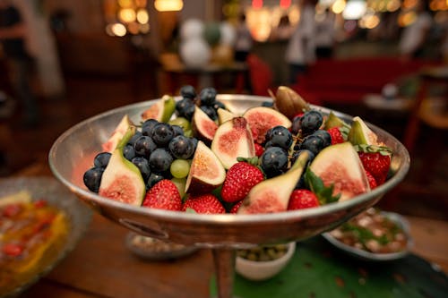 A silver platter filled with fruit and berries