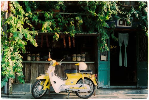 A yellow moped parked outside a restaurant