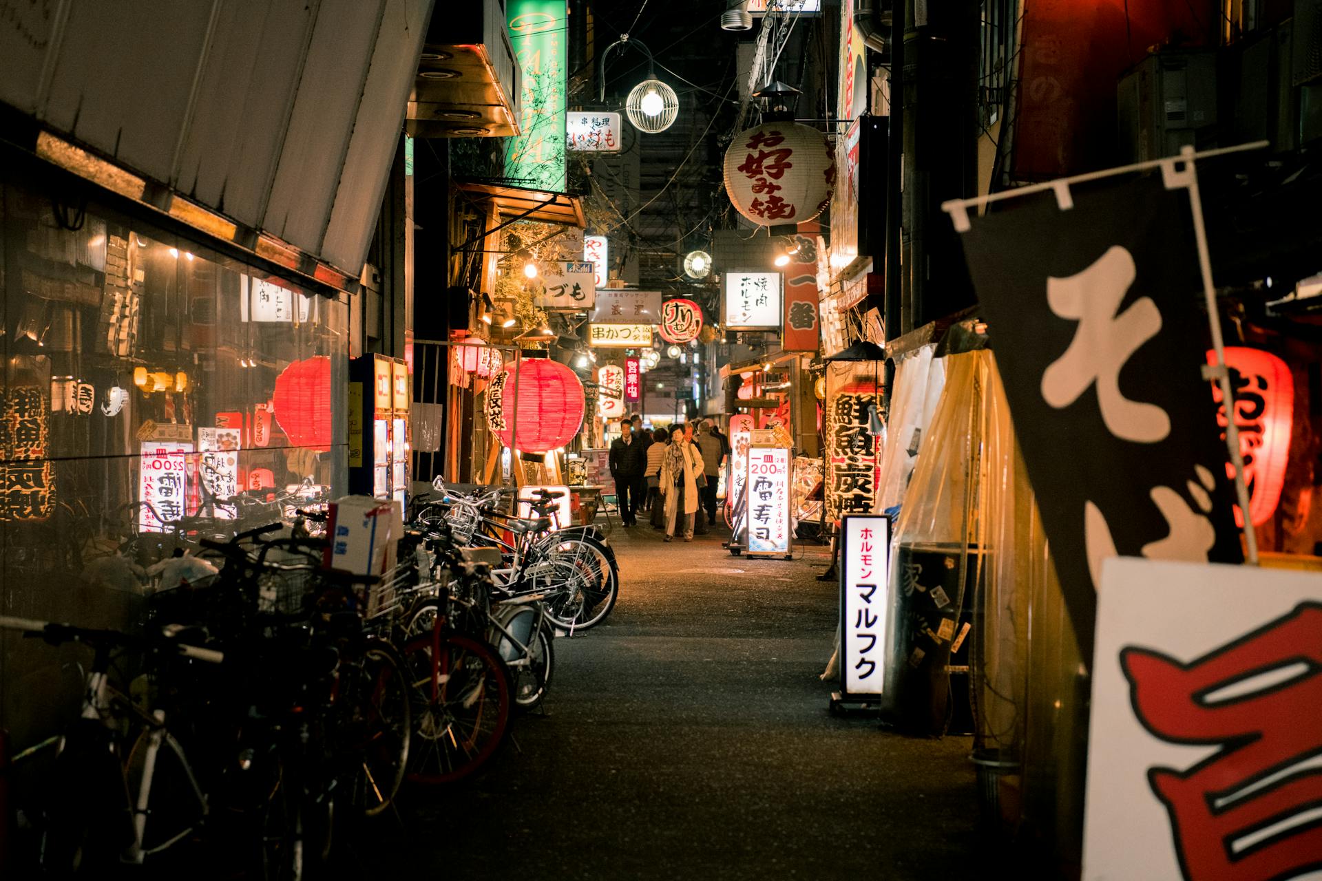 Bicycles Parked Near Japanese Store during Night Time