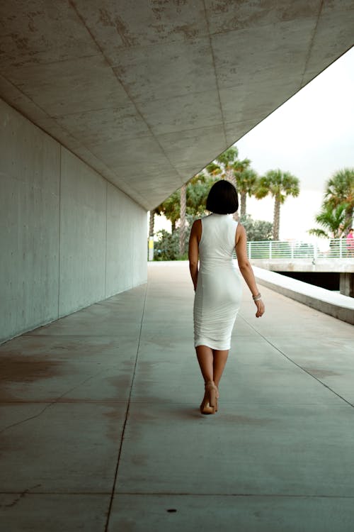 A woman in a white dress walking down a walkway