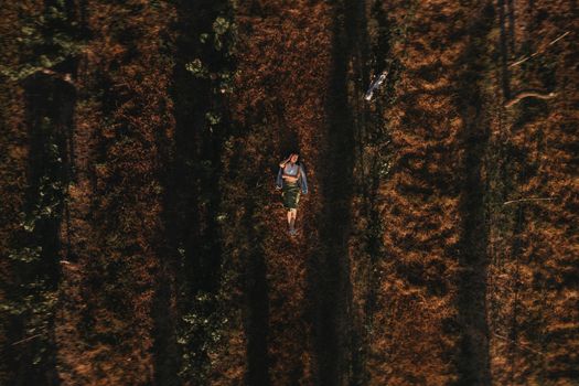 Aerial view of a young woman lying in a rural vineyard during fall season.
