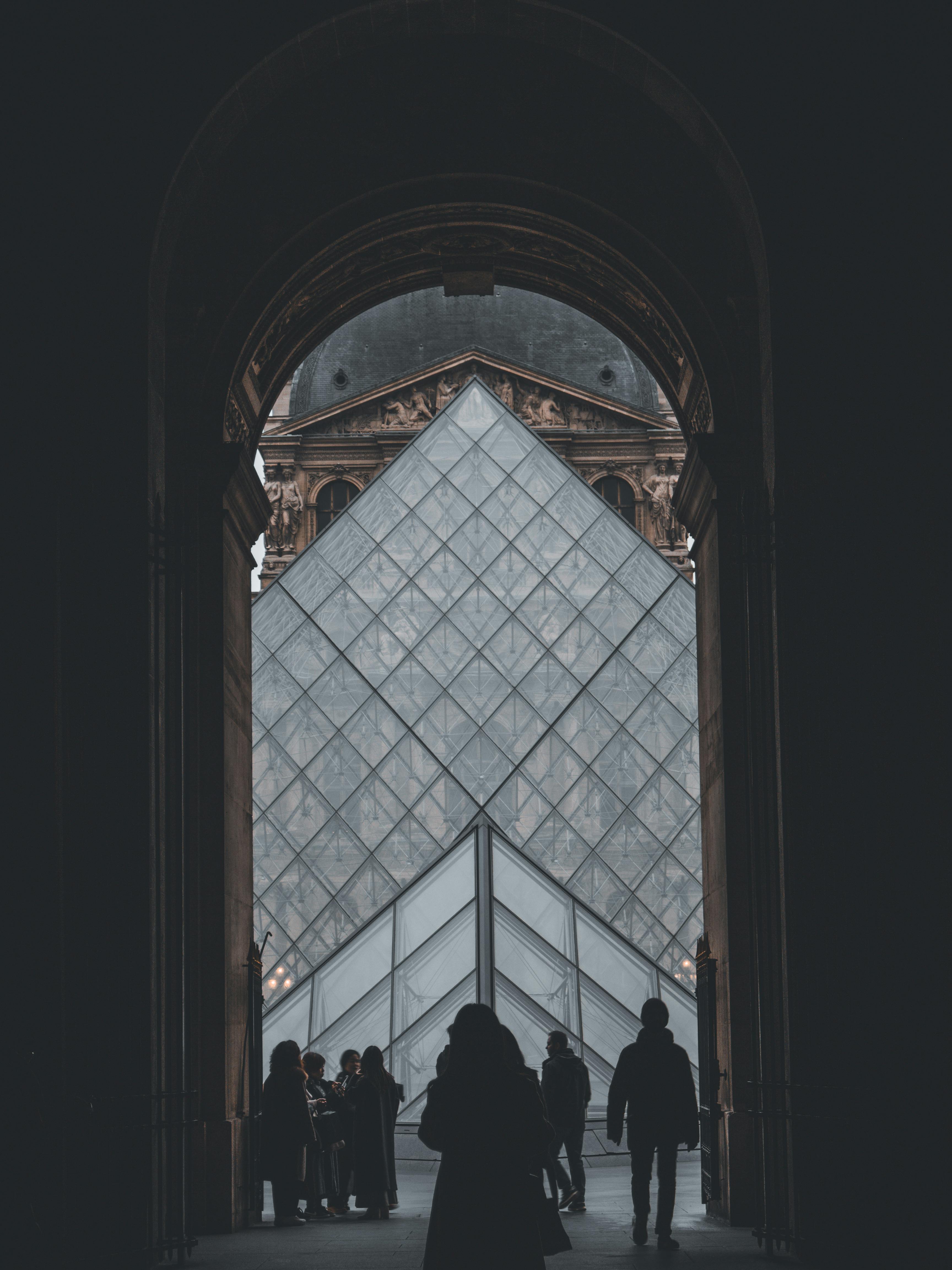 Silhouettes of People Walking Toward the Louvre Pyramid in the ...