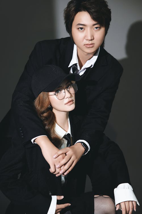 A man and woman in suits posing for a photo