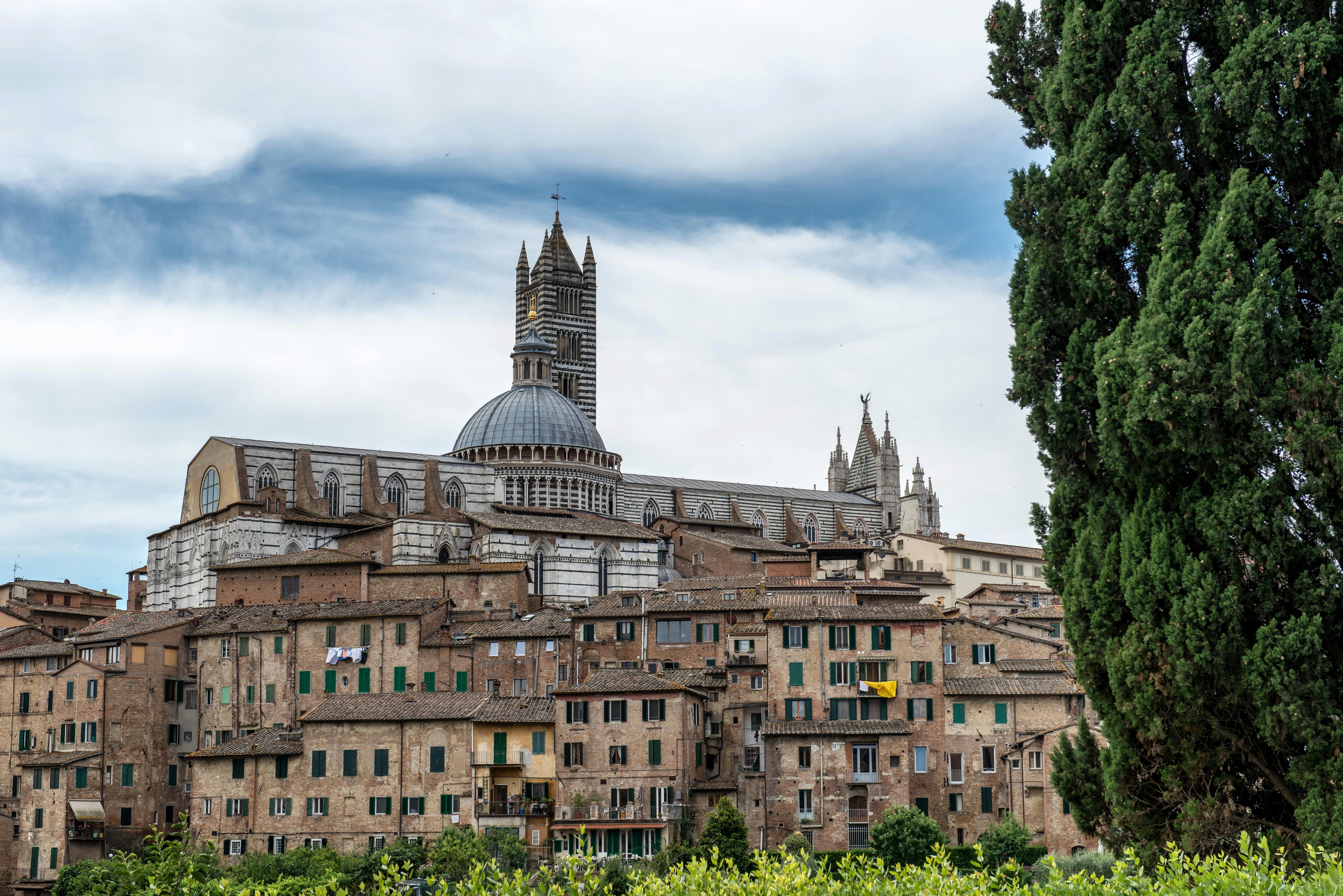 Beautiful cityscape of Siena featuring the iconic Siena Cathedral against a dramatic sky. - Siena