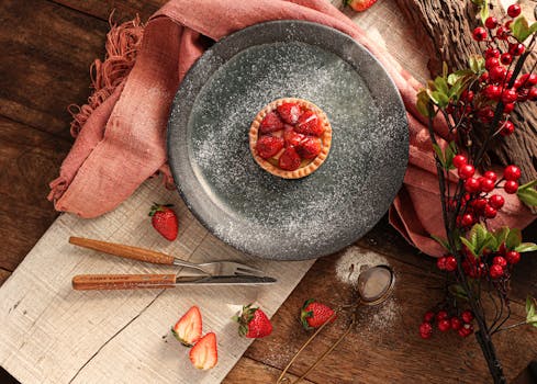A delicious strawberry tart dusted with powdered sugar on a rustic wooden table.