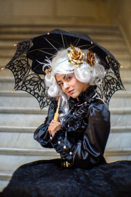 A woman in a black and white costume holding an umbrella