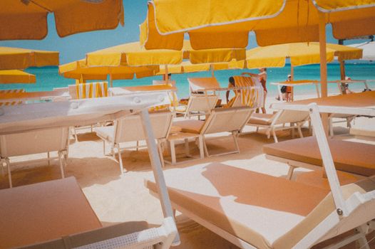 Sunny beach with yellow umbrellas and sun loungers, perfect for a summer vacation.