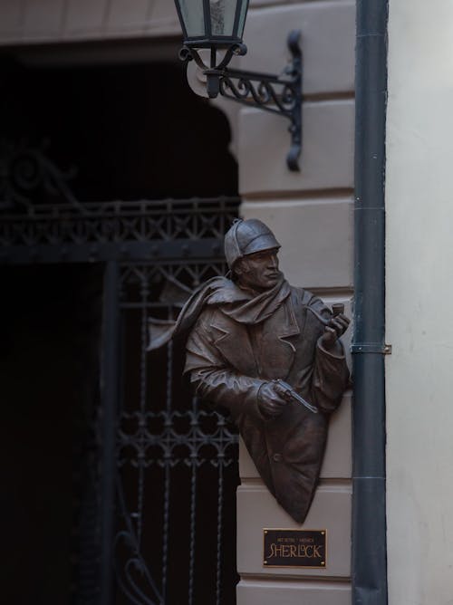 Free A bronze statue of a man holding a hat and a pipe Stock Photo