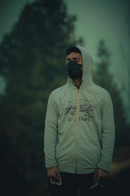 A man wearing a hoodie and a mask