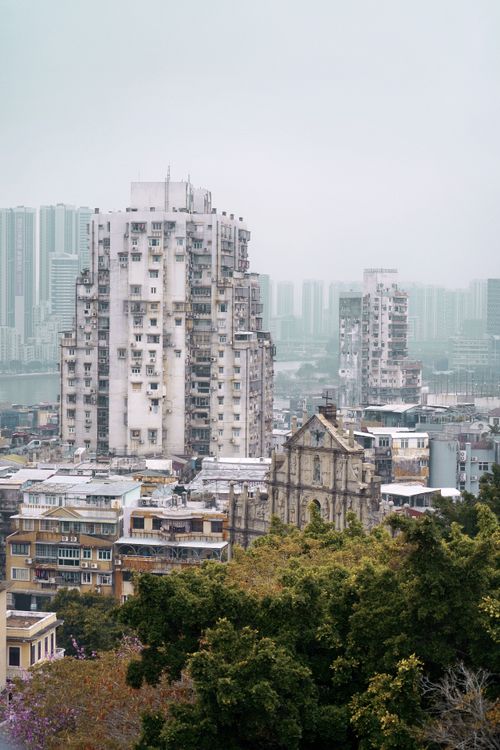 Free Diverse cityscape with modern skyscrapers and a historic landmark amidst greenery. Stock Photo