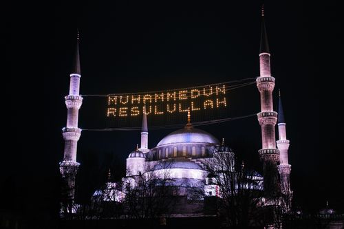 Free Illuminated Blue Mosque at night in Istanbul, showcasing minarets and religious text. Stock Photo