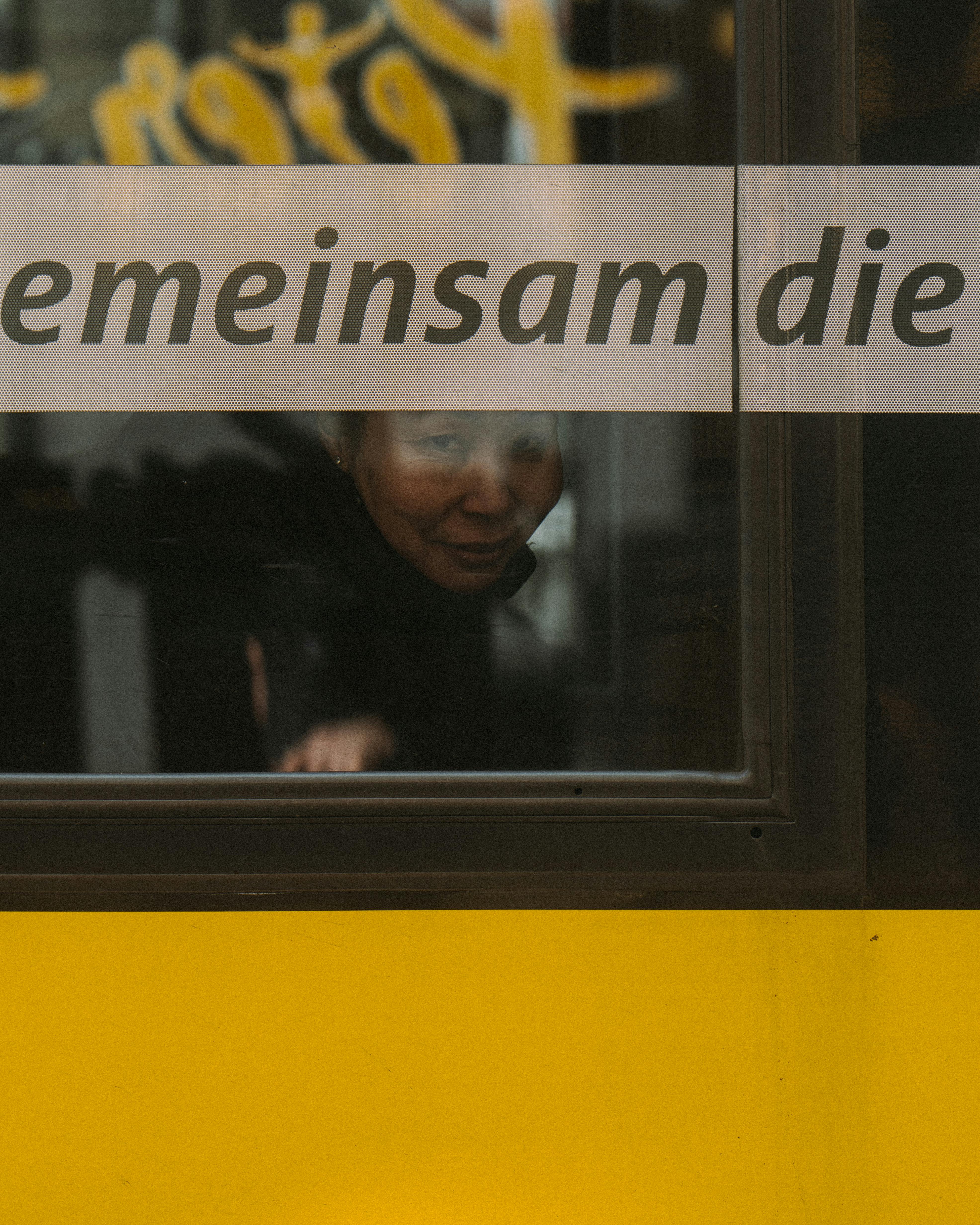 A woman gazes out of a Berlin commuter train window, capturing urban transit's introspection.