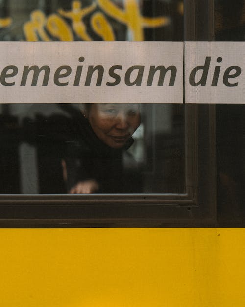 A woman is looking out of a window on a bus