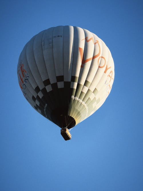 A hot air balloon flying in the sky with the words, 'the best way to travel'