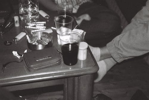 A person sitting on a table with a glass of alcohol