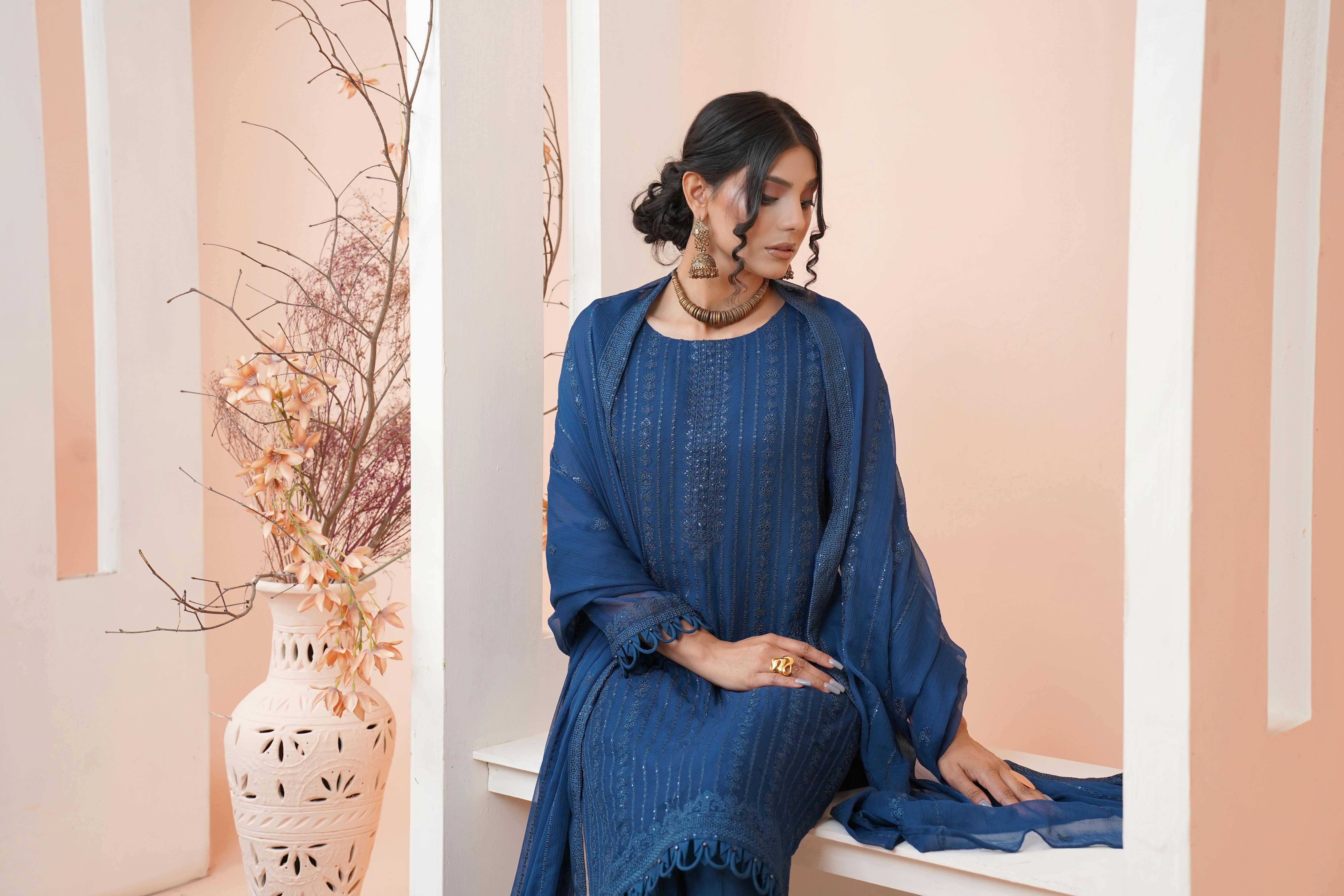brunette woman sitting in blue traditional dress