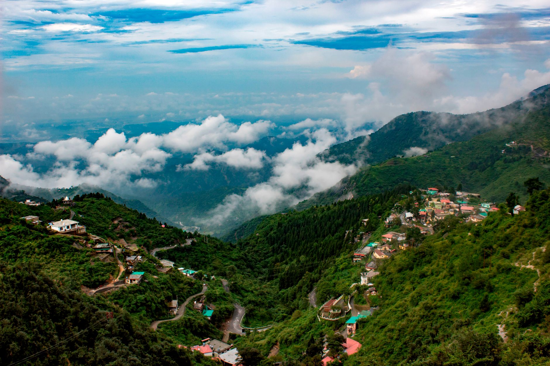 Captivating view of lush mountains and clouds in Mussoorie, India, showcasing natural beauty.