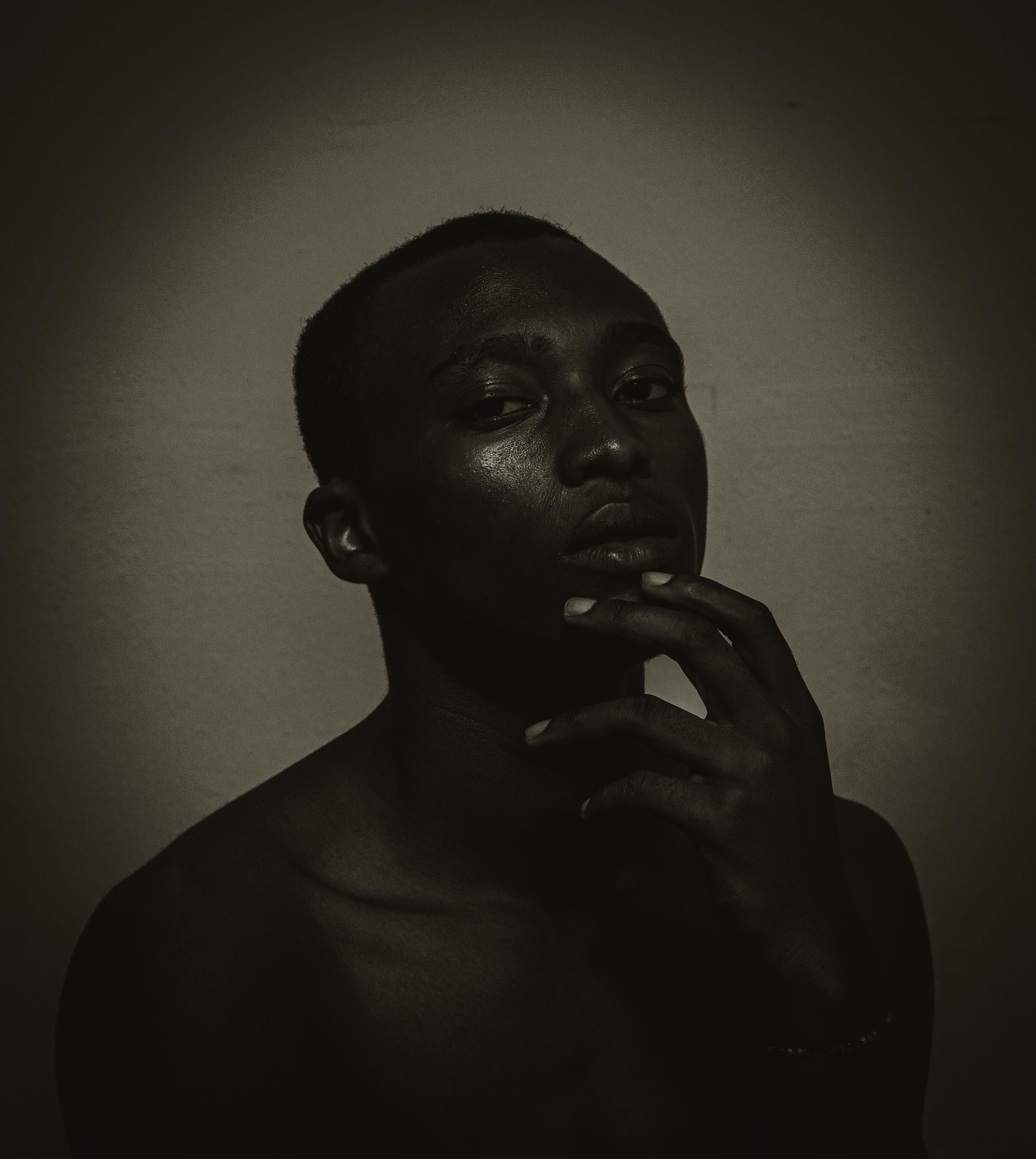 A black man with his hand on his chin · Free Stock Photo