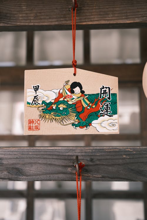 A japanese woman is holding a small card with a picture of a dragon