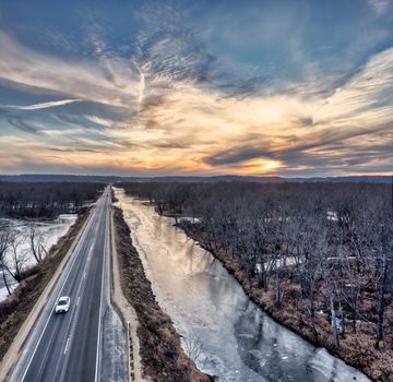 Aerial view of a road and frozen river during winter at sunset in Nelson, WI.